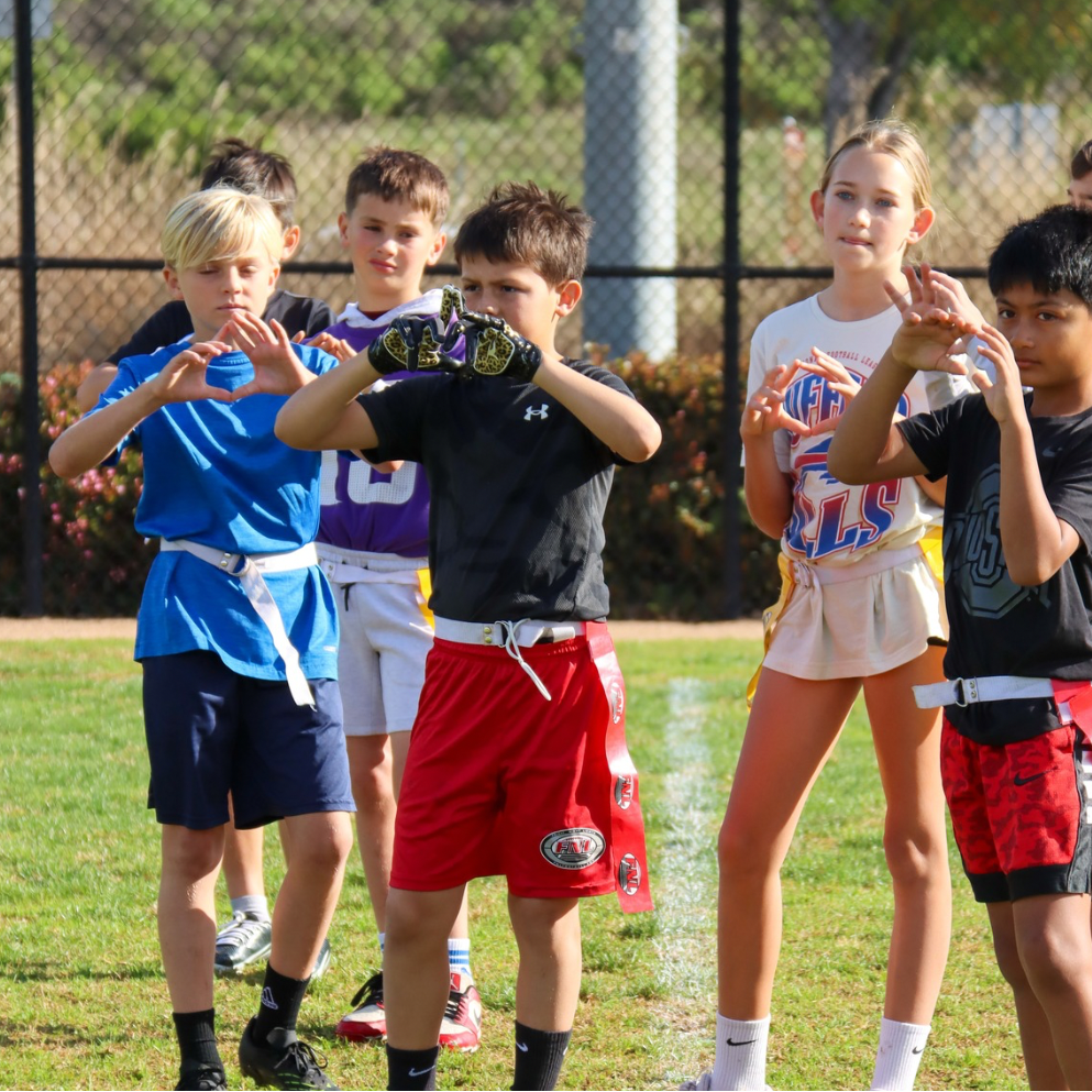 Kids practicing flag football catching drills